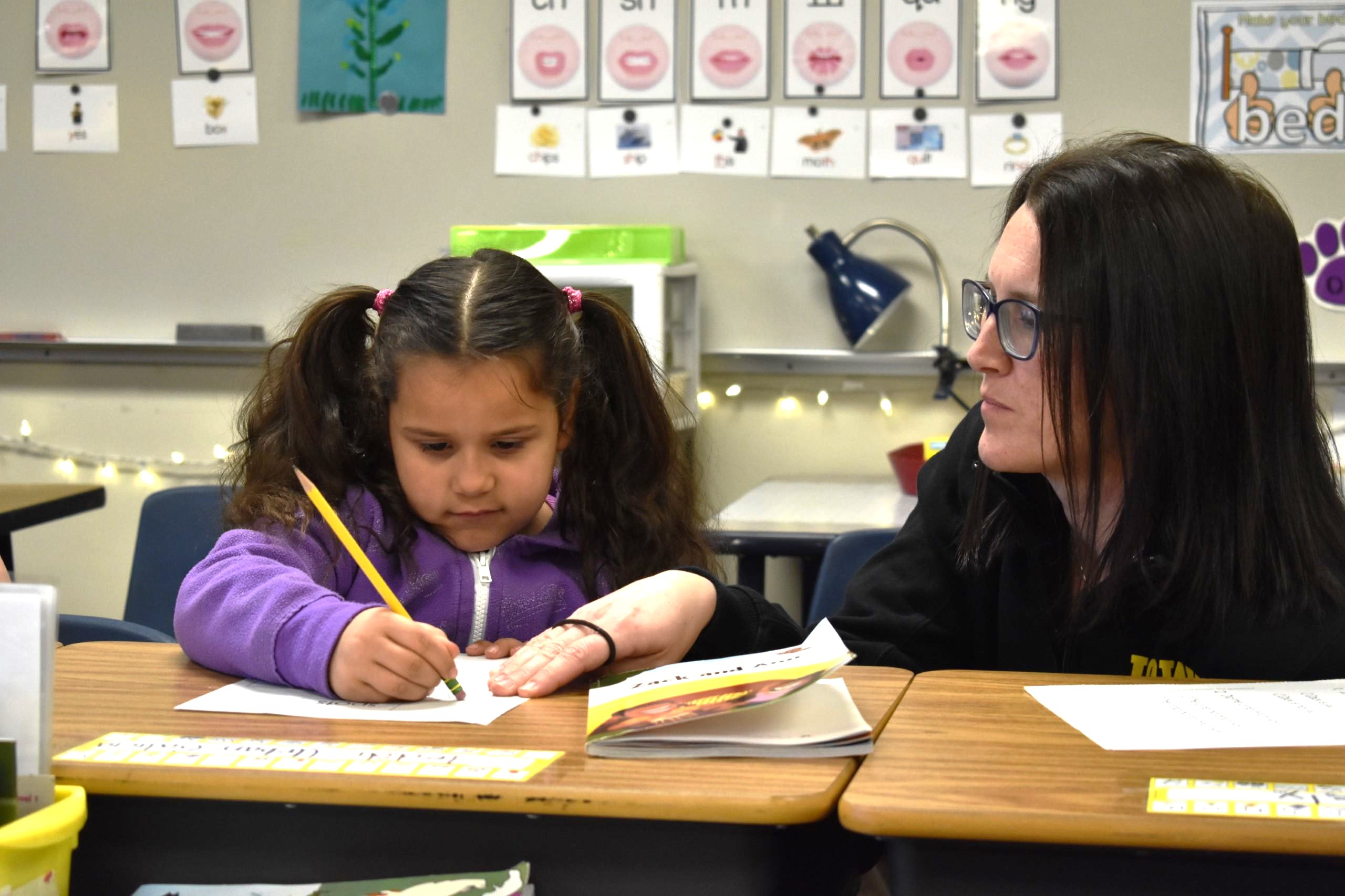 IRRC educator helps a student with a writing exercise during class