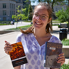 Meg Mechelke holding copies of "The Haunting of Hill House" and "The Golden Compass."