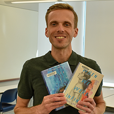 Sean Thompson holding copies of the books "Made You Up" and "When We Were Infinite."