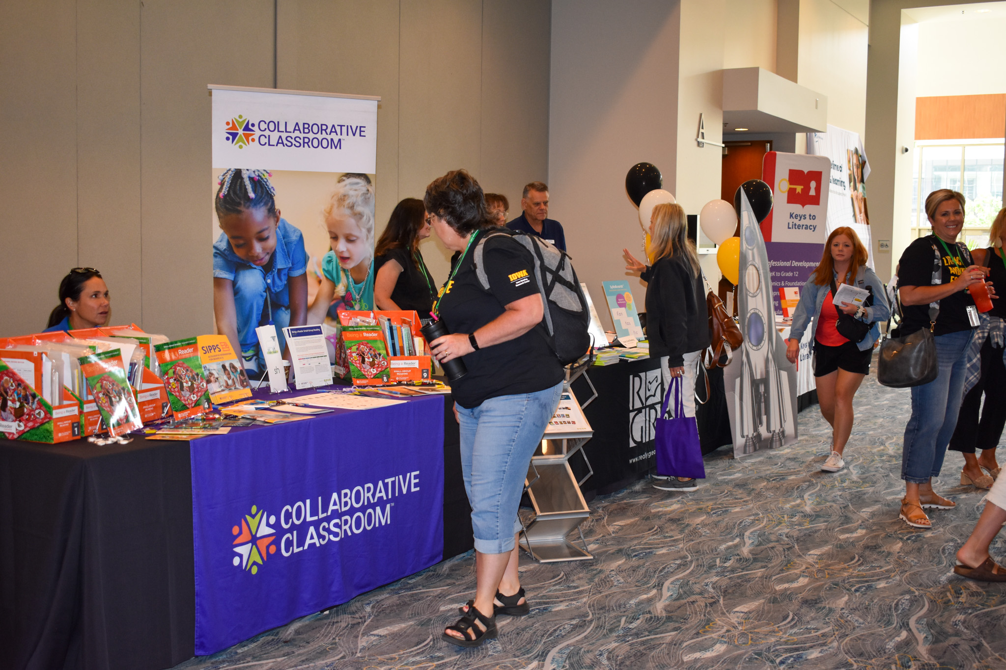 Summit attendees visit the Collaborative Classroom sponsor booth