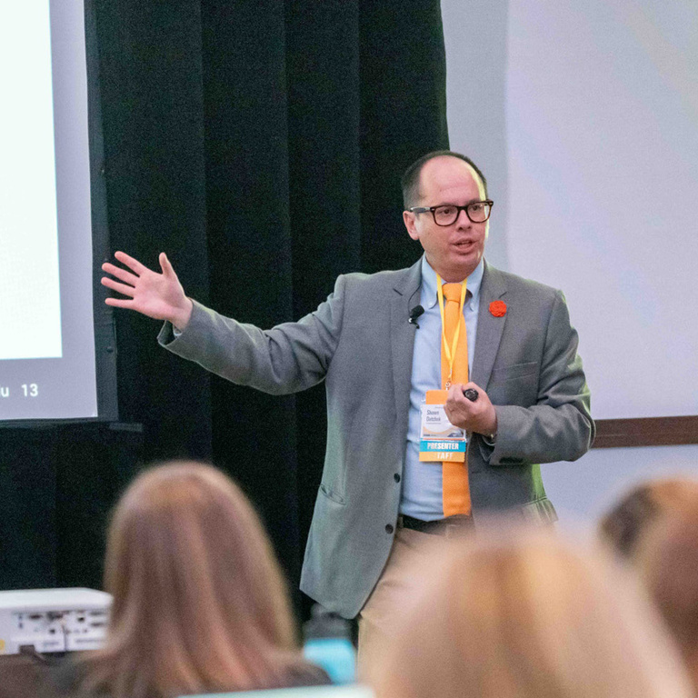 IRRC Director Shawn Datchuk extends his arm during a presentation.