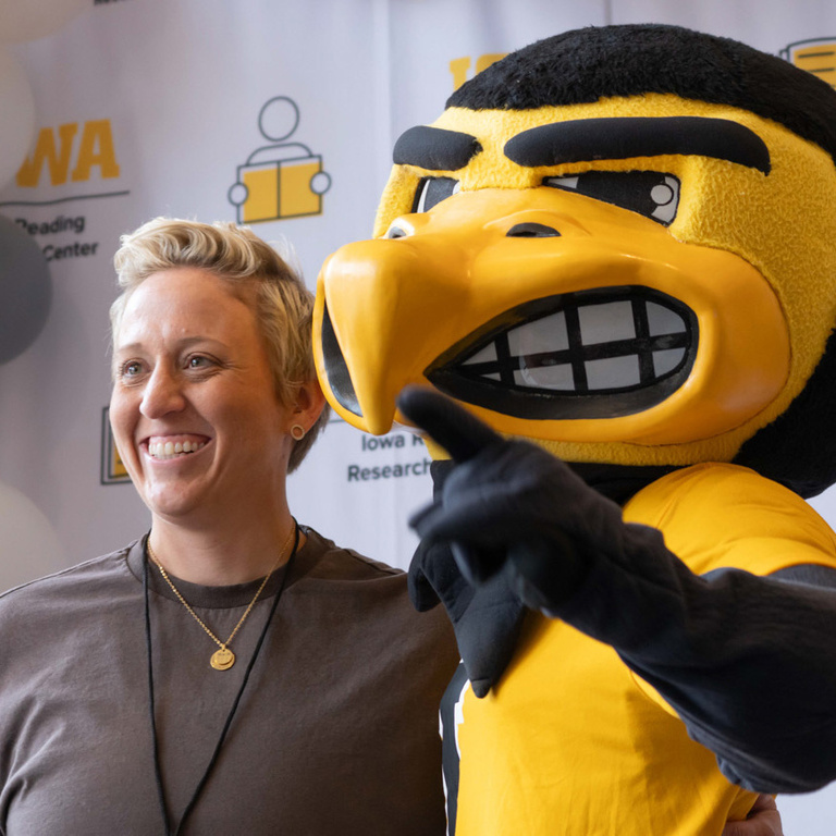 Teacher poses for photo with Herky.