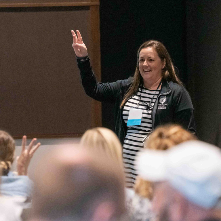 Woman holds up her hand while presenting.
