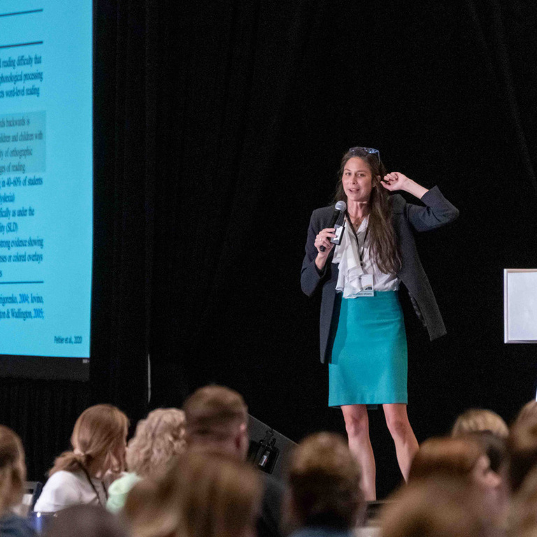 Featured speaker at summit presents on stage.