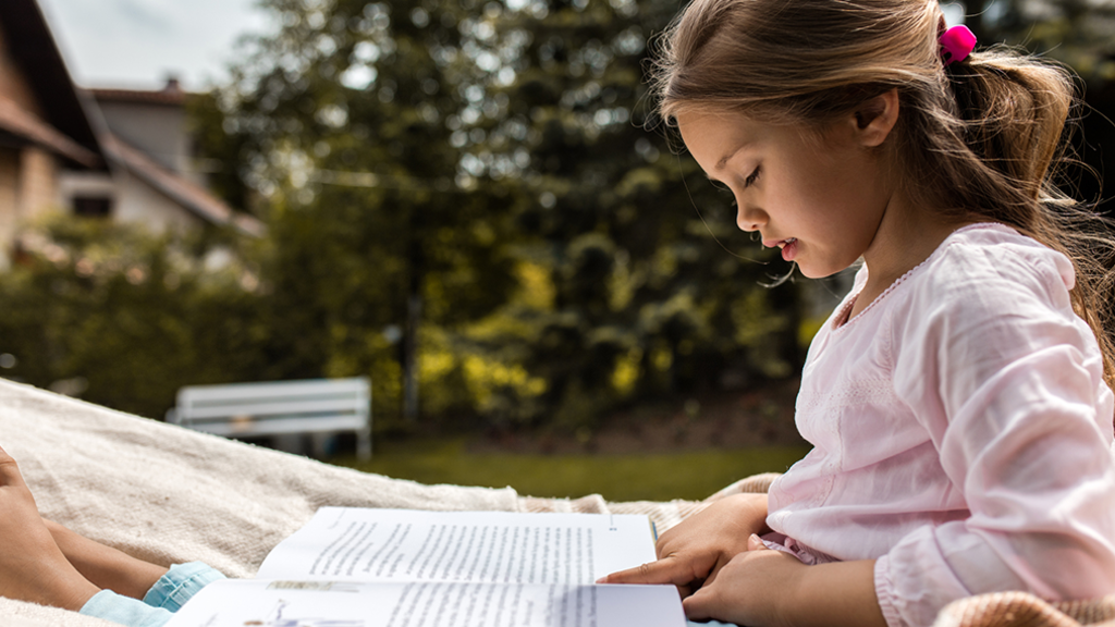  A young girl reading outdoors on a nice summer day