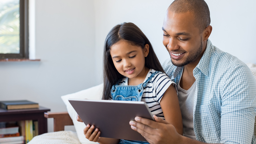 A father and his daughter read something on a tablet