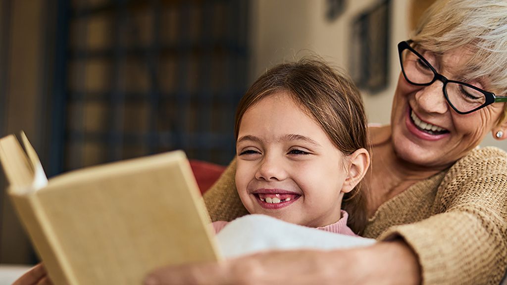 woman reads to child sitting in her lap
