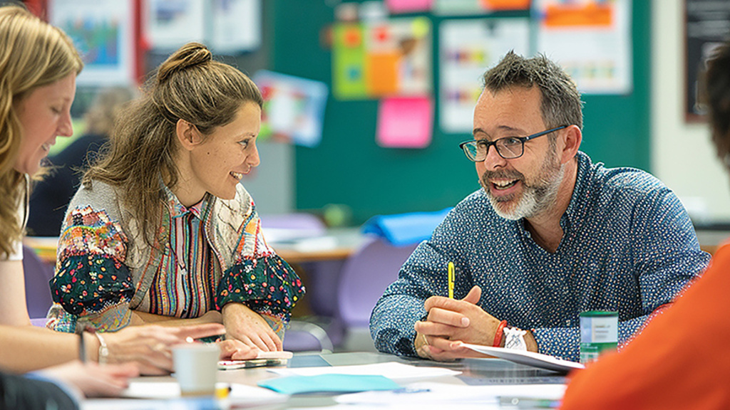 teachers sit around a table